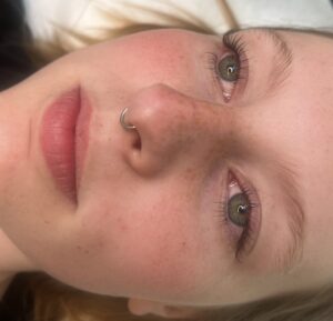 A close up of a person 's face with pink lipstick