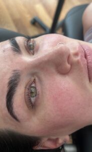A woman with green eyes and pink lips.