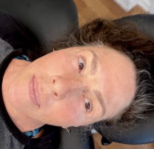 A woman with long hair is sitting in a chair.