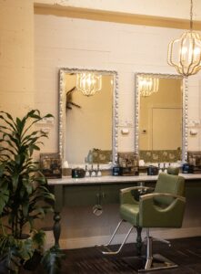 A room with two mirrors and a chair