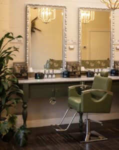 A green chair in front of a mirror.
