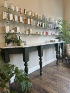 A table with plants and shelves of candles