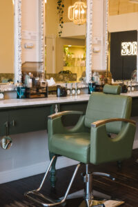 A green chair in front of a mirror.