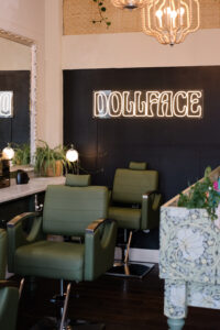 A room with two green chairs and a black wall