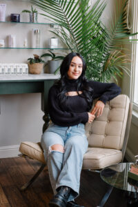 A woman sitting on top of a chair in front of a desk.