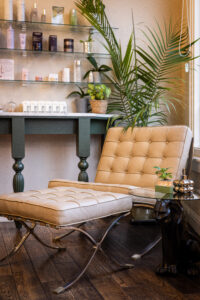 A chair and ottoman in front of a table.