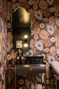 A bathroom with floral wallpaper and a sink.