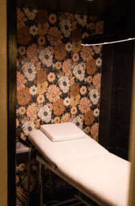 A room with a bed and flowers on the wall