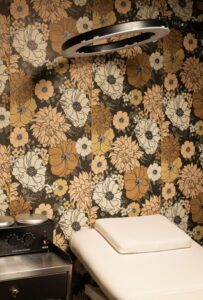 A wall with flowers on it and a white pillow.