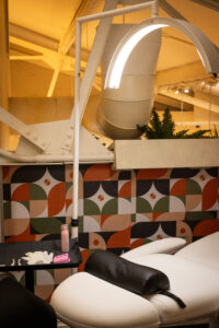 A room with a ceiling fan and a wall of colorful tiles.