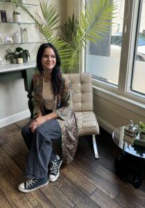 A woman sitting on the floor in front of a chair.