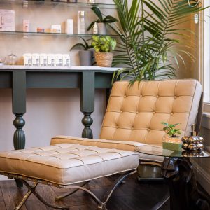 A chair and ottoman in front of a table.